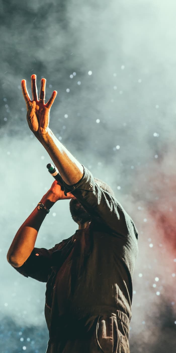 A performer, arm raised, in smoke